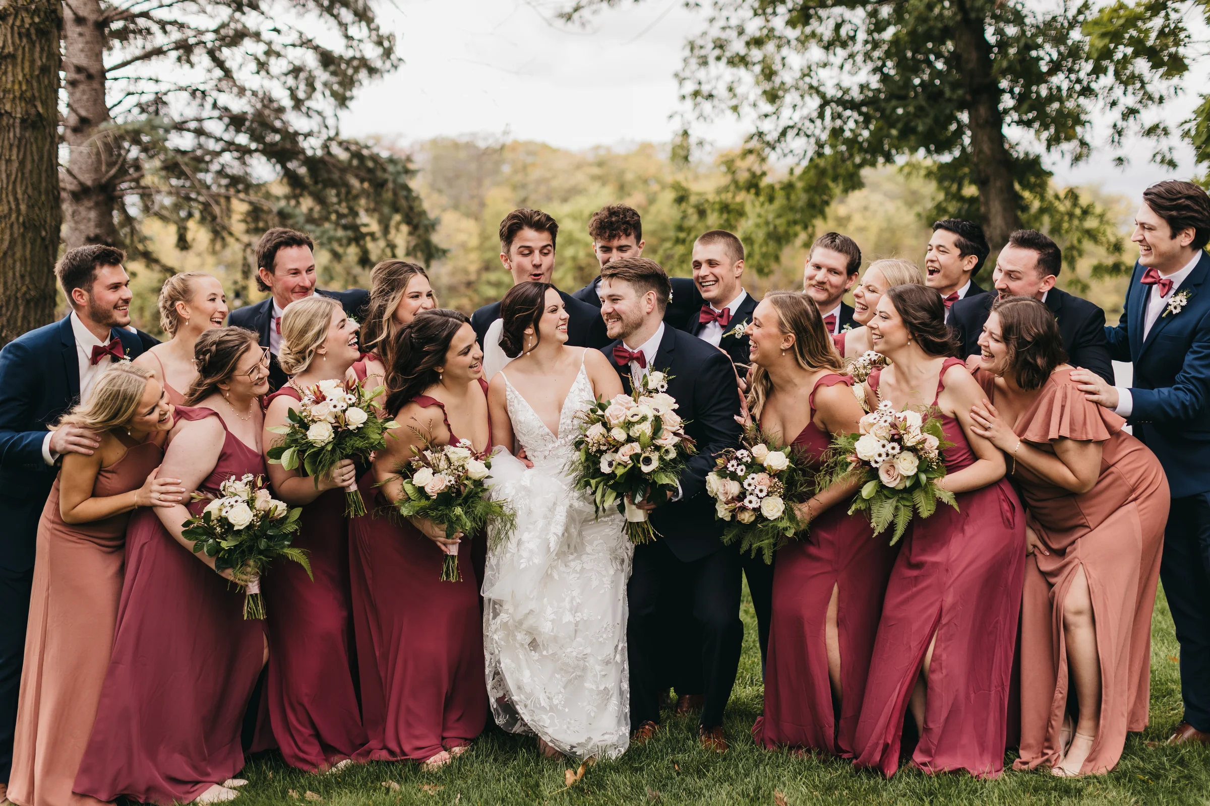 A wedding party gathered on the grounds in the trees