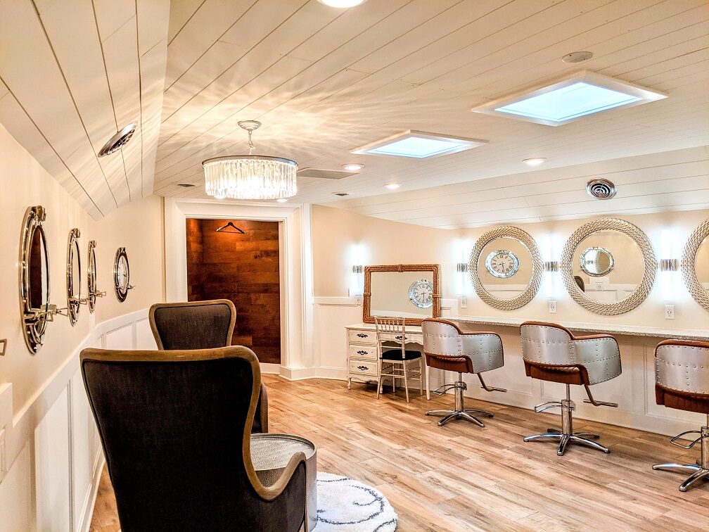 Bright bridal salon with nautical porthole mirrors, a crystal chandelier, and velvet seating at The Chart House, Lakeville MN