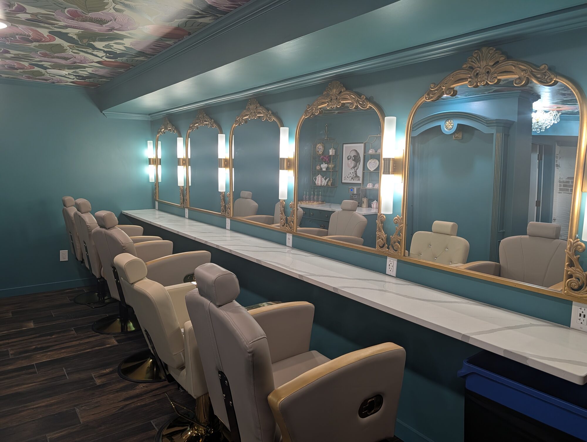 Teal getting-ready salon lined with gilded mirrors, lit vanity sconces, and styling chairs at Glenhaven Events, Farmington MN